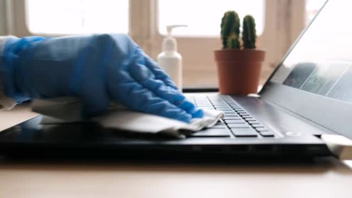 冠状病毒家庭办公室，近距离清洁电脑键盘与洗手液在家工作