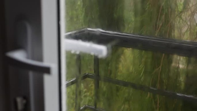 强烈的雨水冲向窗户玻璃并流下来。特写。雨季玻璃背景上的雨滴。4k