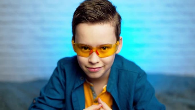 一个十几岁的男孩戴上医用黄色眼镜，以防止病毒疾病。