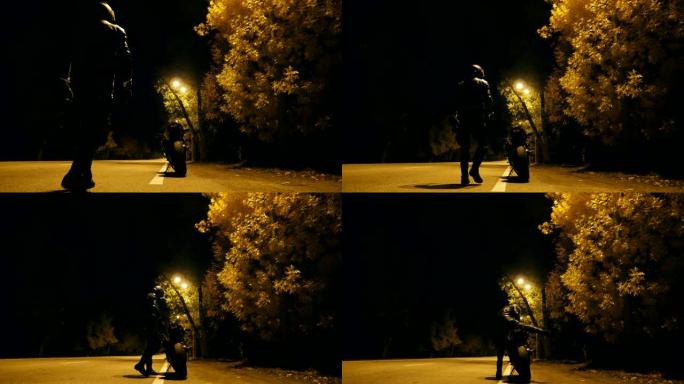 戴着头盔和皮夹克的骑自行车的人来到他的摩托车上，并在夜间高速公路上坐在摩托车上。年轻人打算在晚上骑摩