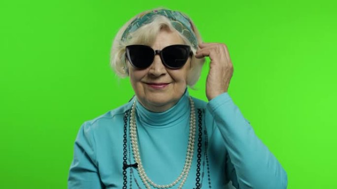 年迈的时尚祖母。白人妇女在色度关键背景上摆姿势