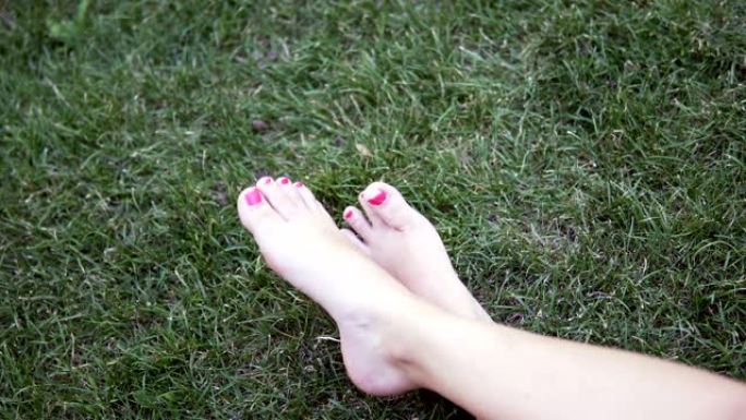 女孩用脚躺在草地上，享受美丽的晴天