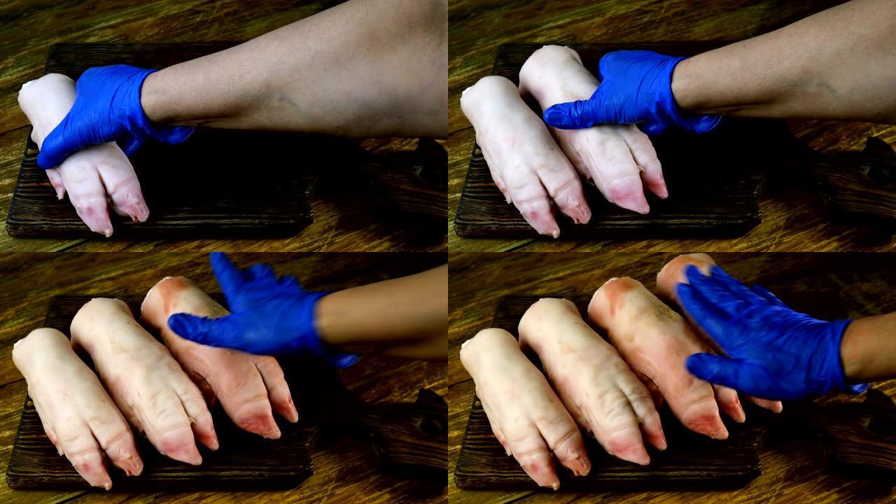 戴着橡胶手套的人的手整齐地将生猪腿放在木制厨房板上。