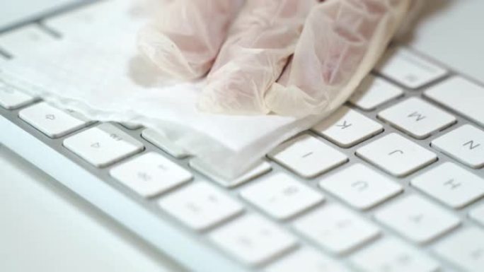 用湿抗菌擦拭彻底清洁和消毒白色脏笔记本电脑键盘，用乳胶手套小心清洁键盘表面，防止危险病毒、微生物和细