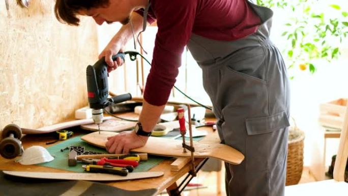 年轻人钻滑板木板做手工木匠设计师