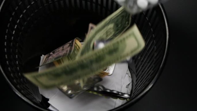 药丸和美元钞票扔进废纸篓的慢动作视频