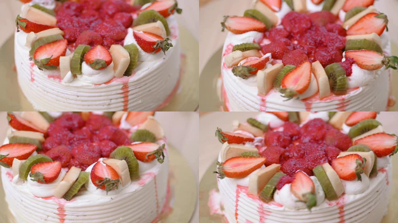 瓦尼拉蛋糕覆盖黄油奶油，装饰有草莓和猕猴桃切片。