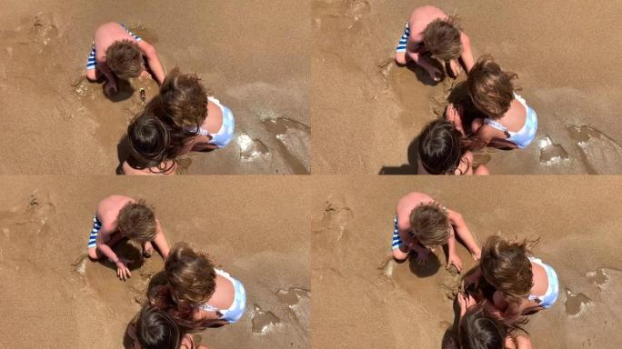 孩子们在沙滩上玩沙子，从海边上方看到的孩子