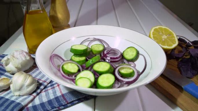 在家准备蔬菜混合沙拉。加入黄瓜片。