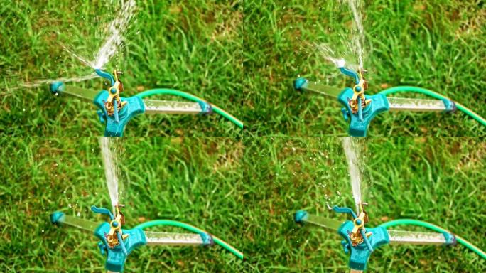 三脚架上的洒水器在slomo俯视图中撒水在草地上撒水