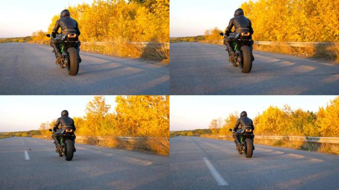 无法识别的人在秋季高速公路上骑着现代运动摩托车。摩托车手在乡间小路上骑摩托车。骑自行车的人在旅行中驾