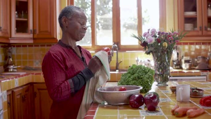 漂亮的退休黑人妇女在厨房里洗菜