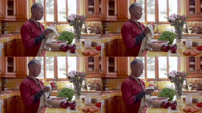 漂亮的退休黑人妇女在厨房里洗菜