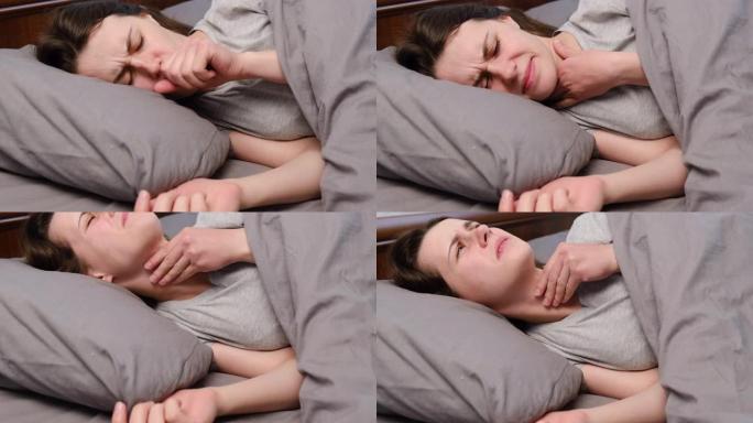 特写生病的年轻女子躺在床上患有咽喉痛，触摸颈部，有不适或疼痛的感觉，患有心绞痛或扁桃体炎的女性身体不