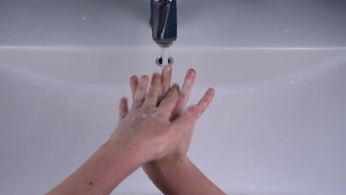 女孩在脸盆上用肥皂洗手。