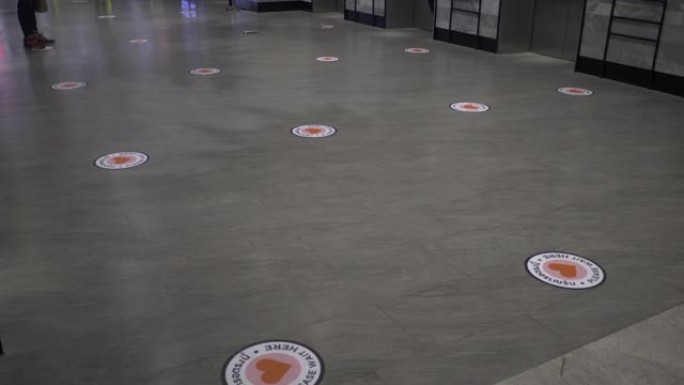 地板上的贴纸可以找到人们在等待电梯时应该站立的位置，以保持社交距离