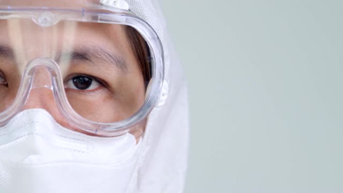 穿着防护危险品PPE套装戴着口罩和眼镜的亚洲医生睁开眼睛，有复制空间
