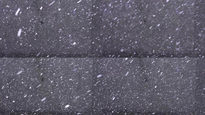 雪花落在灰色沥青上，高于视图。第一场降雪