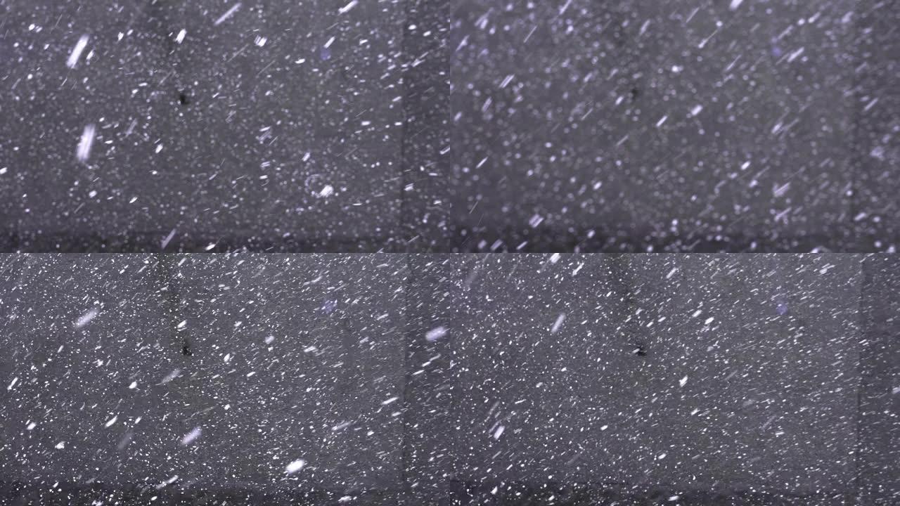 雪花落在灰色沥青上，高于视图。第一场降雪
