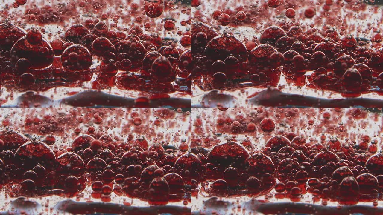 半透明的红色水滴慢慢落在果冻状的表面上