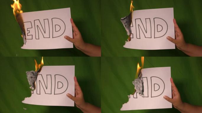 一只手握着燃烧的纸，上面写着文字。