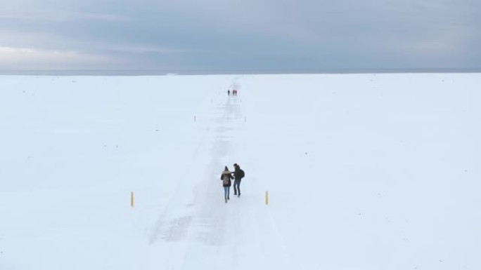 一群旅行者朋友在冬天在冰岛的雪地沙漠上行走