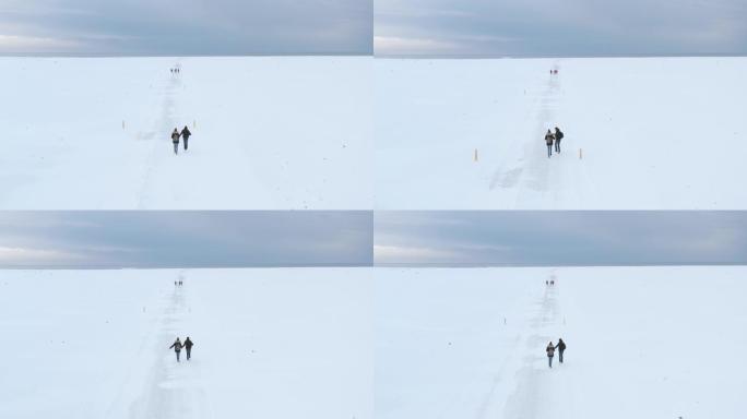 一群旅行者朋友在冬天在冰岛的雪地沙漠上行走