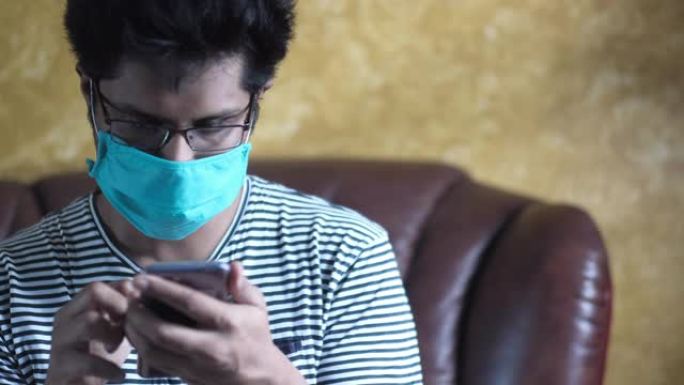 男子戴口罩防传染使用智能手机