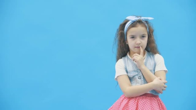 小女孩在4k慢动作视频中决定蓝色背景。