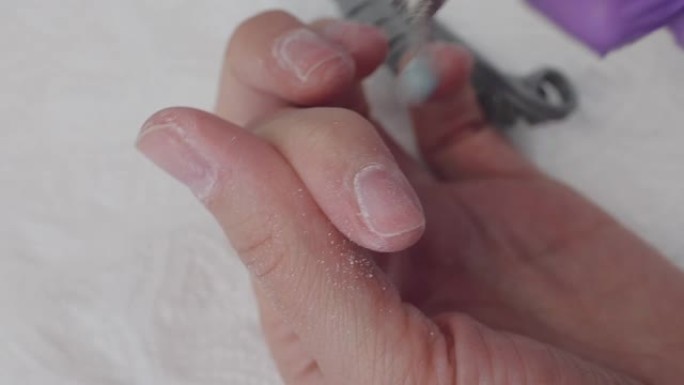 年轻女子使用修指甲机从指甲上去除凝胶虫胶，特写镜头