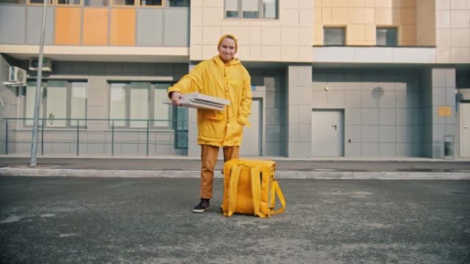 穿着黄色衣服的男子快递员送食物-拿着披萨盒和微笑