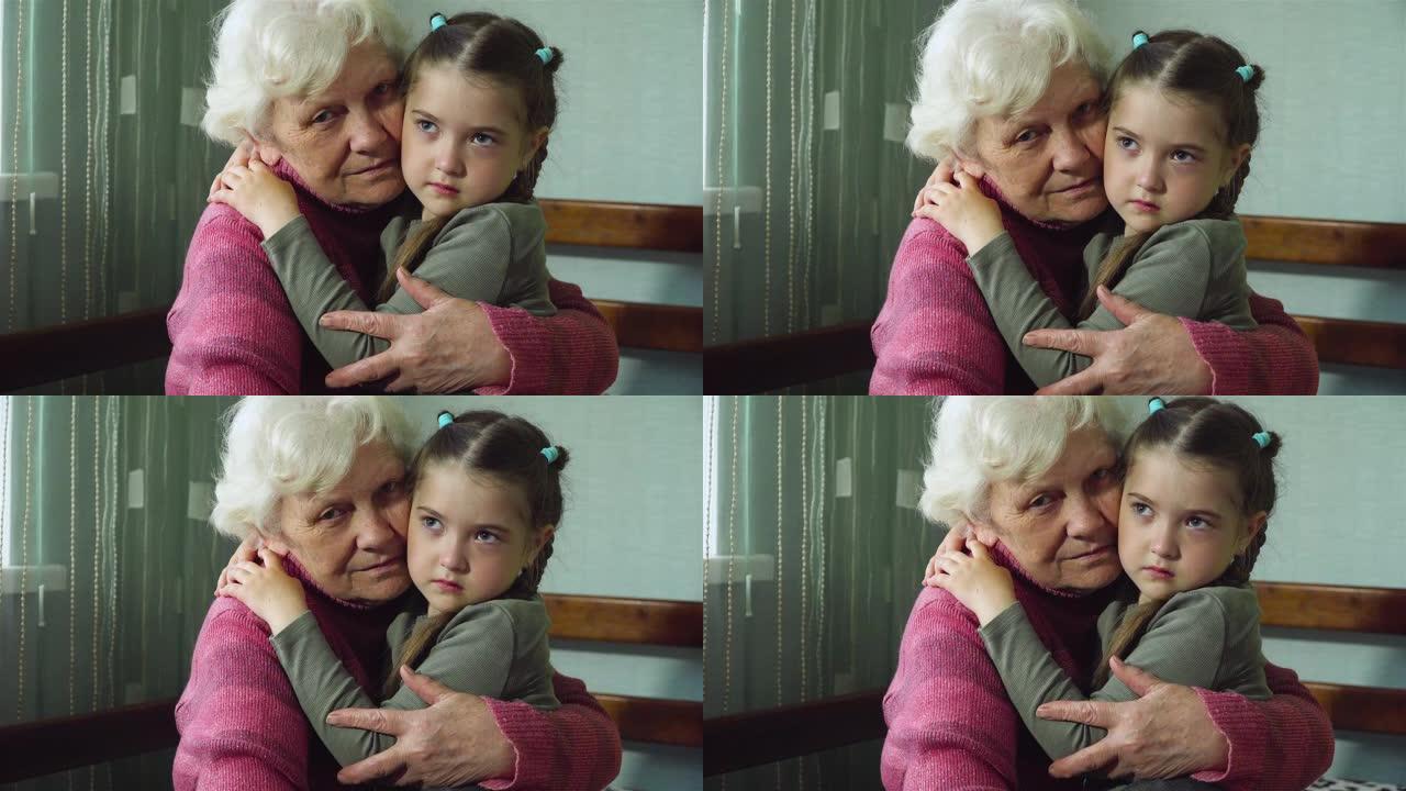 深情快乐的成年老奶奶和可爱的可爱悲伤的小孩孙女看着相机。两代人之间的温暖关系