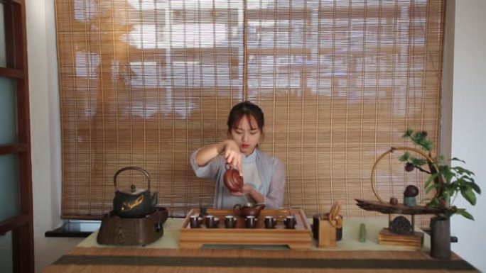 一位亚洲年轻女士正在喝茶表演
