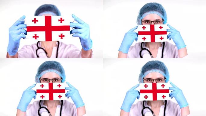 特写镜头。医生戴着眼镜，戴着蓝色医疗帽，双手握着带乔治亚旗的医疗口罩。在冠状病毒全球流行期间，医生护