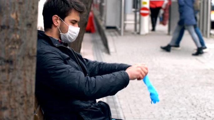 男子在公共场所戴着手套，戴着口罩。冠状病毒症状。