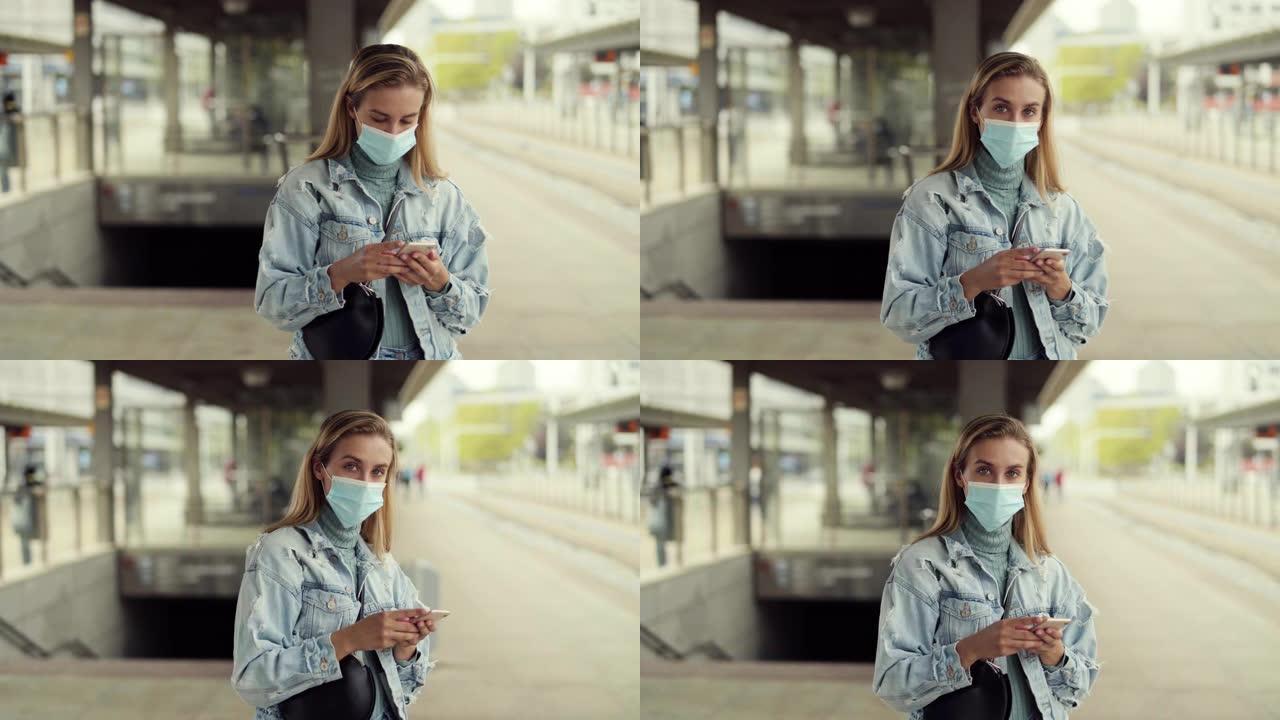 戴着口罩的年轻金发女子在汽车站等着，用电话。