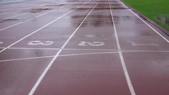 雨天在体育场跑步。轨道上有数字。