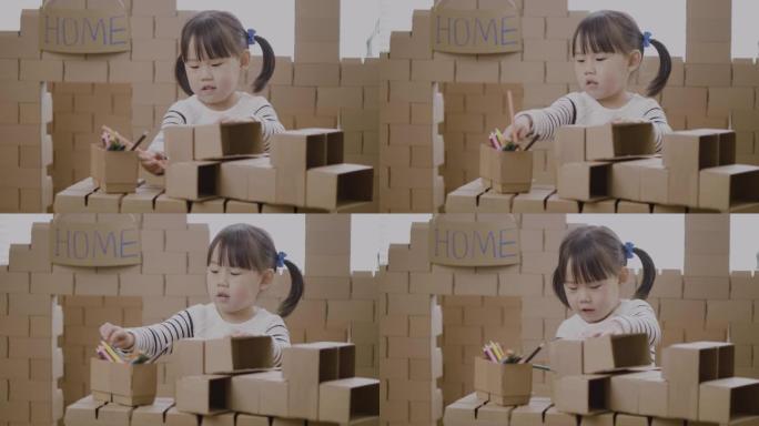 蹒跚学步的女孩使用纸箱块制作家庭教育的动物工艺品