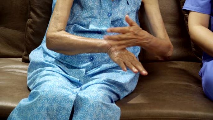 老年妇女使用护理人员的洗手液凝胶来帮助保护f