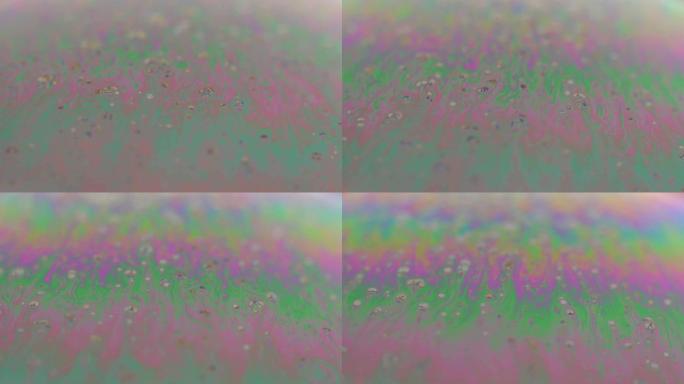 来自肥皂泡的迷幻抽象行星，肥皂泡上的光折射，肥皂泡中的宏观特写。黑色背景上的彩虹色。宇宙星系或行星模