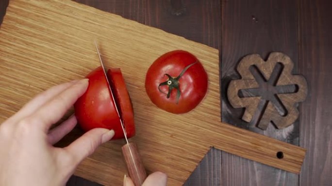 厨师在木板上切割番茄锋利的钢刀
