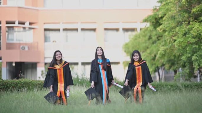 一位从大学毕业的亚洲女毕业生微笑着祝贺她毕业于大学。