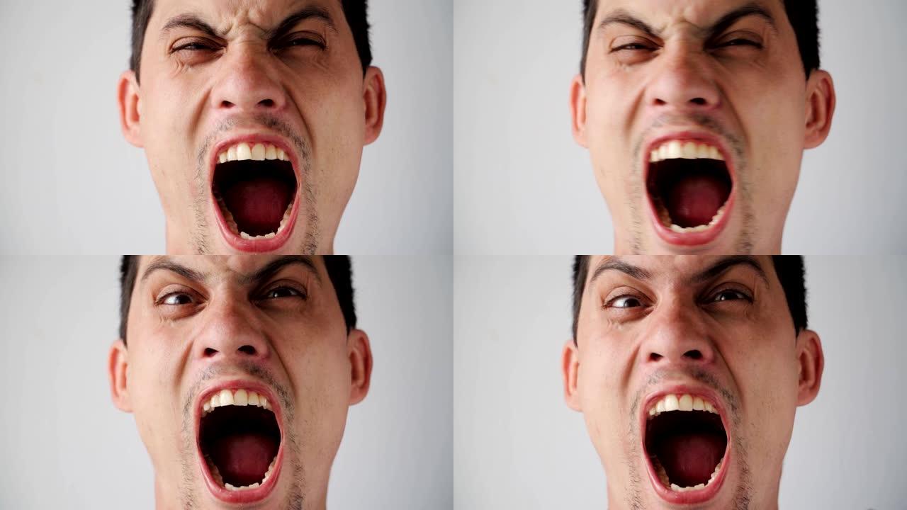 年轻的高加索愤怒的家伙的肖像直接对着镜头大喊。男人在白色背景上的情感。慢动作。特写。
