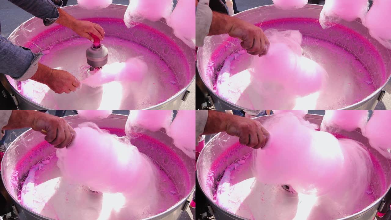 男人将甜棉绒从糖制成粉红色的棉绒，用牙线制成