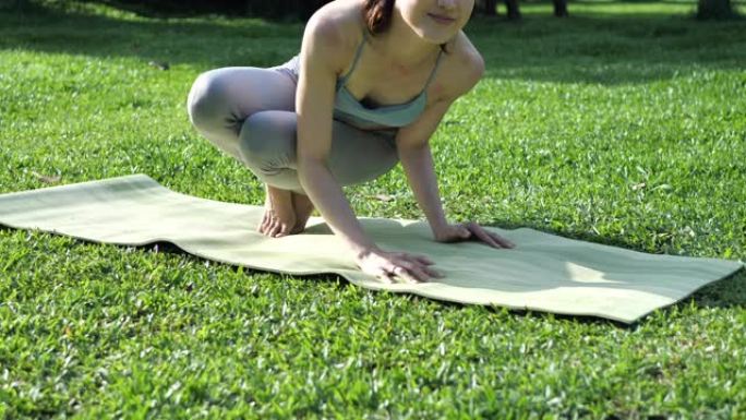 亚洲美丽的年轻女子在禁闭期间在公园锻炼瑜伽