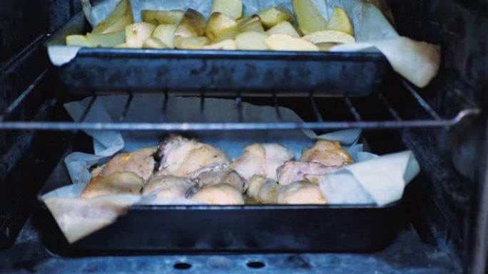 烤鸡鸡腿，土豆在烤箱里烤。用烤箱里煮熟的脆皮臀部烘烤。侧视图。