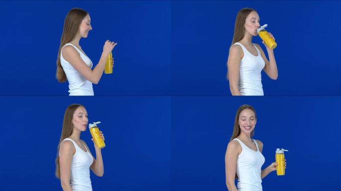 美丽的长发女孩喝运动瓶中的橙汁; 简介。