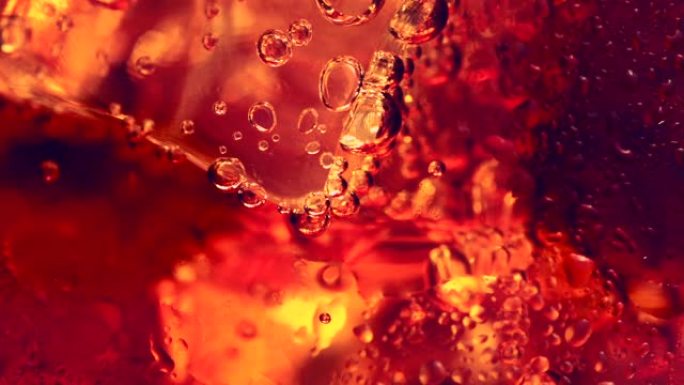 带冰和气泡的可乐，微距拍摄。抽象甜食液体背景
