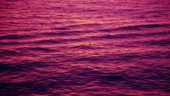 反射粉红色日落余辉的波纹波