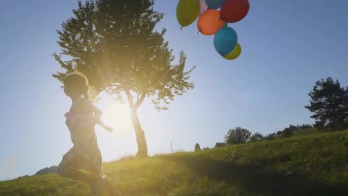 慢动作跟踪镜头，拍摄了一个女孩在蓝天下随风奔跑的气球。